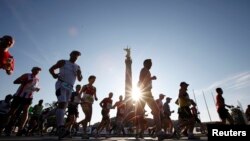 Los corredores pasan por la Columna de la Victoria al inicio de la 38ª Maratón de Berlín, el 25 de septiembre de 2011.