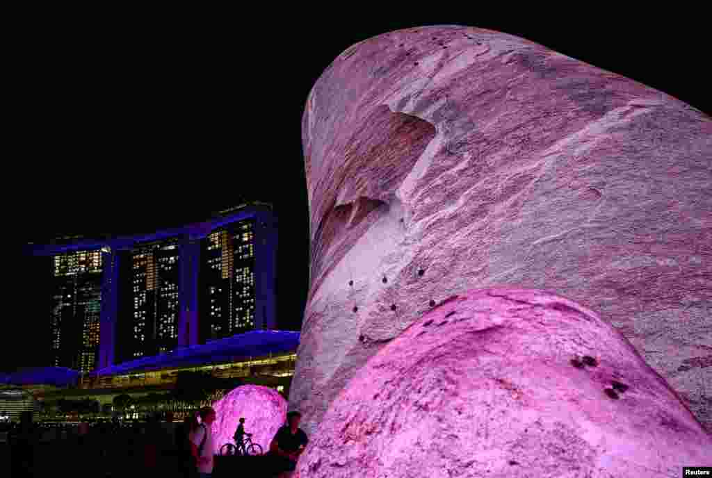 People interact with the Iwagumi Air Scape light art installation by Australian studio ENESS during the i Light Festival at the Marina Bay in Singapore.