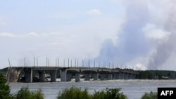 Esta vista general muestra un área parcialmente inundada cerca del Puente Antonovskiy (REAR) en las afueras de Jersón, el 6 de junio de 2023, luego de los daños sufridos en la represa hidroeléctrica Kakhovka.