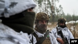 Militares ucranianos vestidos con camuflaje de nieve participan en un entrenamiento militar en un lugar no revelado en la región de Kharkiv, Ucrania, el 1 de diciembre de 2023.