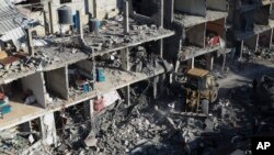 Palestinians look at the destruction after an Israeli strike on residential buildings and a mosque in Rafah, Gaza Strip, Thursday, Feb. 22, 2024.