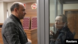 La periodista de Radio Europa Libre/Radio Libertad (RFE/RL, por sus siglas en inglés), Alsu Kurmasheva, acusada de violar la ley rusa sobre agentes extranjeros, habla con su abogado Edgar Matevosyan en una audiencia judicial en Kazán, Rusia, el 23 de octubre de 2023.
