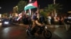 Demonstrators wave Iran's flag and Palestinian flags as they gather at Palestine Square in Tehran, Iran, on April 14, 2024, after Iran launched a drone and missile attack on Israel. 