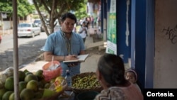 Mientras reportaba en Masaya, Nicaragua, el periodista Wilfredo Miranda conversa con una vendedora de frutas. [Cortesía]