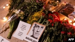 This photograph taken on Feb. 17, 2024, shows portrait placards, flowers and candles displayed as a tribute in Paris to Alexey Navalny after the announcement that the Kremlin's critic had died in an Arctic prison. China described Navalny's death as 'Russia's internal affair.'