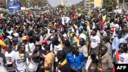 Des groupes de la société civile et des groupes politiques tiennent des pancartes lors d'une marche appelant les autorités à respecter la date de l'élection, à Dakar, le 17 février 2024. (Photo JOHN WESSELS / AFP)