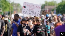 FILE - People march during a Juneteenth event on June 19, 2020, in Milwaukee. Juneteenth marks the day in 1865 when federal troops arrived in Galveston, Texas, to ensure all enslaved people were freed. (AP Photo/Morry Gash)
