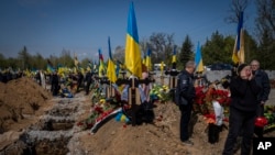 Los sepultureros bajan el ataúd del militar ucraniano Andrii Vorobiov en el cementerio de Kryvyi Rih en el este de Ucrania, el 24 de abril de 2023.