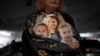 Des photos de Shiri Bibas et ses fils Kfir, 9 mois, et Ariel, 4 ans, lors d'une manifestation pour leur libération, à Tel Aviv, le 21 février 2024. Le Hamas a dit qu'il remettrait leurs corps à Israël dans le cadre de la 1e phase de la trêve s'achevant le 1er mars. (Photo AP)