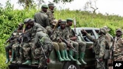 FILE - M23 rebels load a pickup truck in Kibumba, in the eastern of Democratic Republic of Congo, Dec. 23, 2022. .(AP Photo/Moses Sawasawa)
