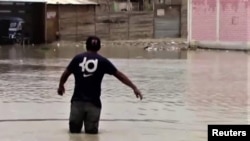 En esta imagen de captura de pantalla de un video publicado por Reuters, un residente en Piura, Perú, camina por una calle inundada debido a las torrenciales lluvias dejadas por el Ciclón Yaku, el 9 de marzo de 2023. Material facilitado por un tercero a Reuters.