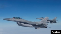 FILE - F-16 fighter jets fly during a NATO media event at an airbase in Malbork, Poland, March 21, 2023.