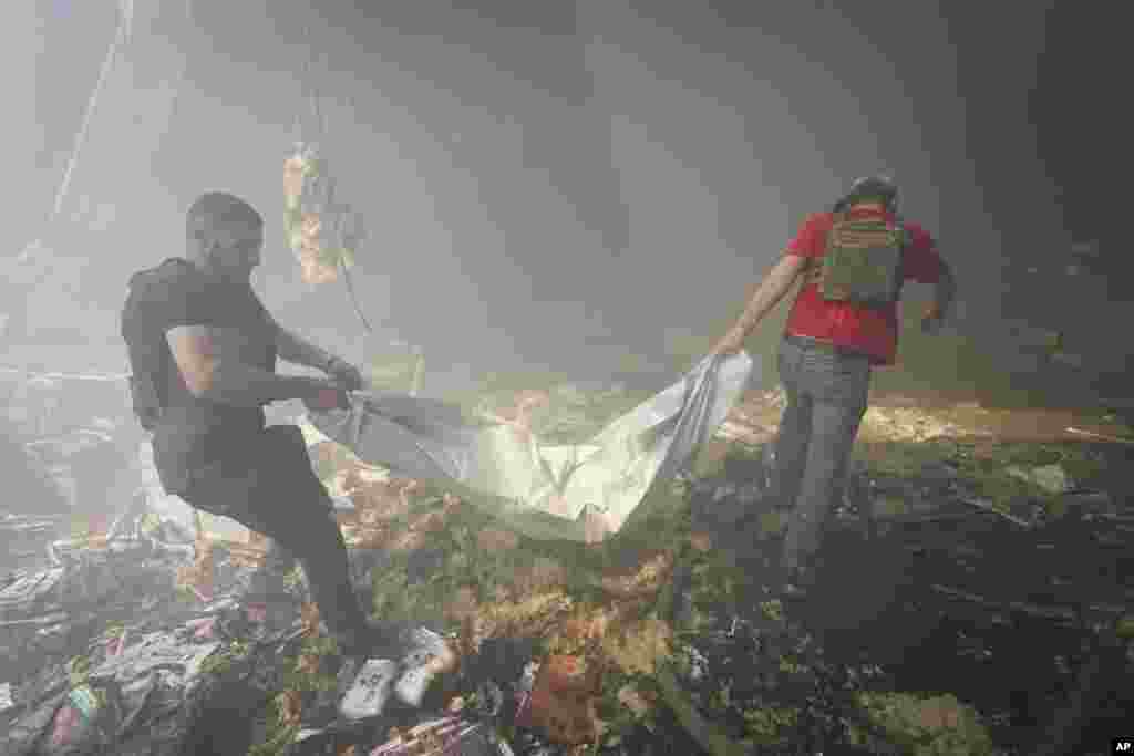 Rescuers carry a body after a Russian missile hit a large printing house in Kharkiv, Ukraine. At least seven civilians were killed, officials said, as Kyiv’s army labored to hold off an intense cross-border offensive by the Kremlin’s larger and better-equipped forces.