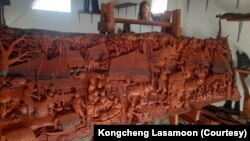 ການຄວັດ ແລະແກະສະຫຼັກໄມ້ເປັນແຜ່ນ ຢູ່ທີ່ໂຮງຊ້າວກອງແຊງ ແກະສະຫຼັກລາຍລາວ.