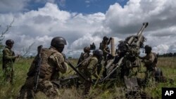 FILE - Ukrainian servicemen prepare to fire at Russian positions from a U.S.-supplied M777 howitzer in Kharkiv region, Ukraine, July 14, 2022. U.S. officials say the Pentagon will announce soon it is sending up to $500 million in military aid to Ukraine.
