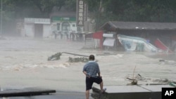 资料照：北京郊区妙峰山一名居民眼看着洪水淹没街道。（2023年8月1日）