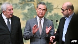 Dari kiri: Mahmoud al-Aloul, perwakilan Fatah, Menlu China Wang Yi, dan Mussa Abu Marzuk, anggota senior Hamas, usai penandatanganan deklarasi di Beijing, Selasa 23 Juli 2024.