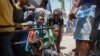 Youth take cover after hearing gunshots at a public school that serves as a shelter for people displaced by gang violence, in Port-au-Prince, Haiti, March 22, 2024.
