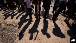 Los migrantes esperan ser procesados ​​por la Patrulla de Aduanas y Protección Fronteriza de EEUU después de cruzar el Río Grande y entrar a territorio estadounidense desde México, el 19 de octubre de 2023, en Eagle Pass, Texas.
