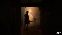FILE - A volunteer sprays mosquito repellent as part of a prevention campaign against dengue fever in Amritsar, India, on July 30, 2023.