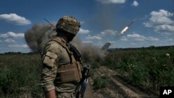 ARCHIVO - Un soldado ucraniano observa un sistema de lanzamiento múltiple de cohetes Grad disparando proyectiles cerca de Bakhmut, región de Donetsk, Ucrania, el 13 de agosto de 2023.