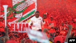 Arquivo: Filipe Nyusi (E), gesticula enquanto faz um discurso durante o último comício da campanha para as eleições gerais moçambicanas em 2019.