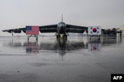 한국 청주 공군기지에 착륙한 미 공군 B-52H 전략폭격기가 앞에 미한 양국 국기가 세워져있다.