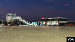 Migrantes venezolanos abordan el avión que los llevará desde Harlingen, Texas, hasta Caracas, Venezuela, en la madrugada del miércoles. Se trata del primer vuelo de deportación directa desde EEUU a territorio venezolano en más de cuatro años. [Fotografía: Laura Sepúlveda, VOA]