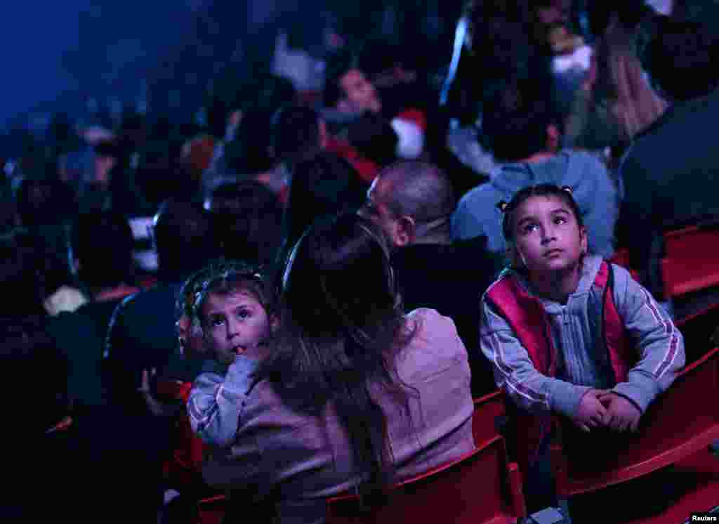 Espectadores disfrutan de la ceremonia de inauguración de los Juegos Panamericanos que comenzó con un solo de tambor interpretado por una mujer con un vestido rojo brillante y terminaron con un concierto de rock y fuegos artificiales.