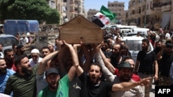 Syrians attend the funeral procession of a man killed during clashes with Turkish troops, in Afrin in northern Syria on July 2, 2024.
