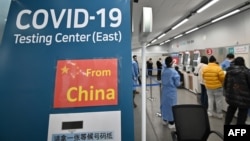 韩国检疫工作人员在仁川国际机场COVID-19新冠疫情检测中心引导从中国抵达的旅客。(2023 年1月3日)