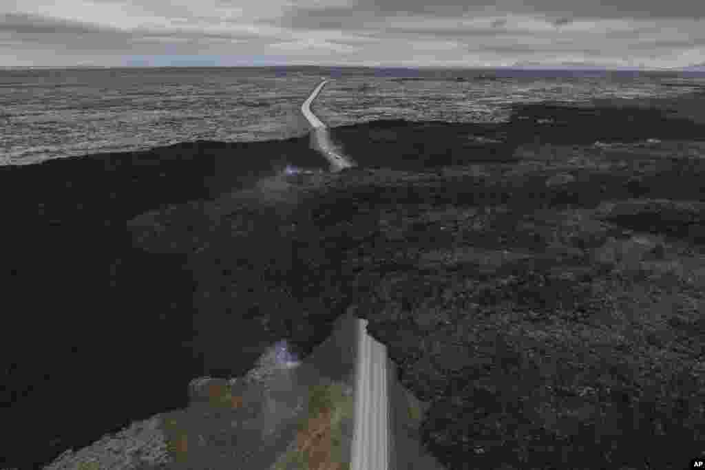 An aerial view shows lava from an active volcano engulfing the road near Grindavik, Iceland, June 8, 2024.