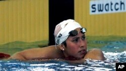 FILE - Janet Evans leans on the lane ropes after finishing the 400 meter freestyle at the 1996 Summer Olympics in Atlanta, July 22, 1996. Evans won four swimming golds at the 1988 and 1992 Games and recalls the never-easing pressure to perform.