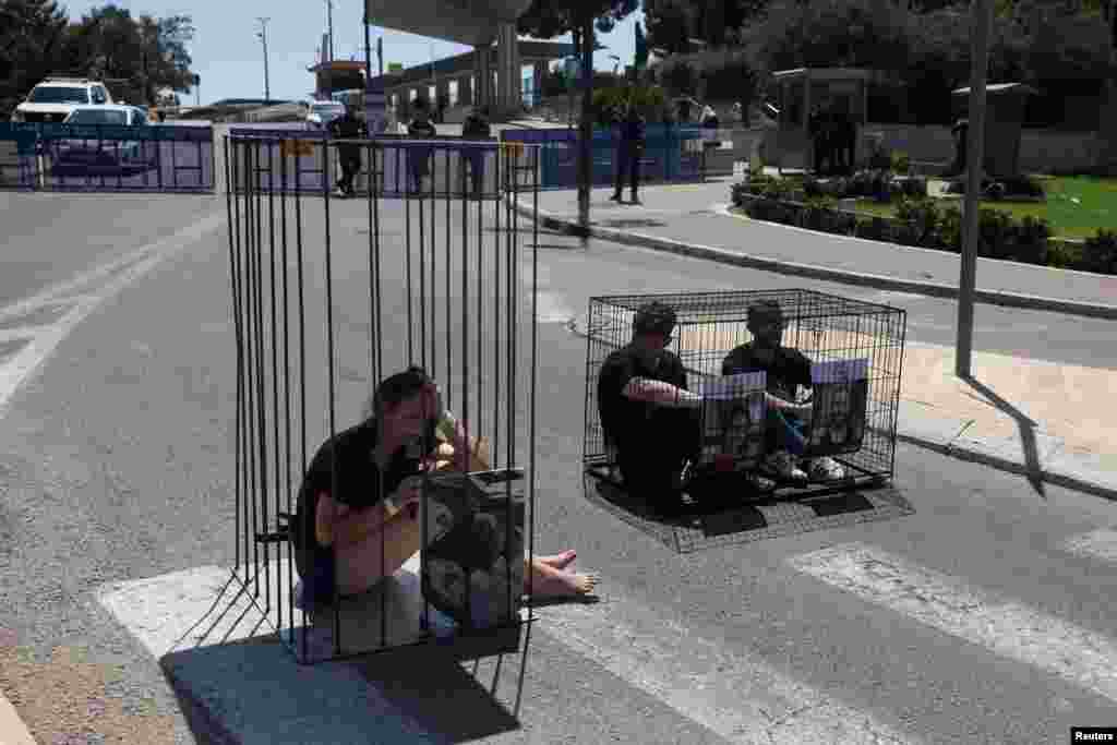Family members of Israeli hostages held in Gaza since the deadly October 7 attack by Hamas, protest in cages to have their loved ones returned, outside the Knesset, Israel's parliament, in Jerusalem.