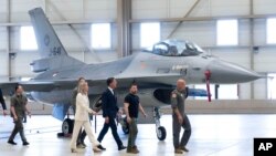 El presidente de Ucrania, Volodymyr Zelenskyy, segundo a la derecha, y el primer ministro interino neerlandés, Mark Rutte, en el centro, observan los aviones de combate F-16 en Eindhoven, Países Bajos, el 20 de agosto de 2023.