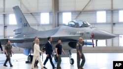 Ukrainian President Volodymyr Zelenskyy, second right, and Dutch caretaker Prime Minister Mark Rutte, center, look at F-16 fighter jets in Eindhoven, Netherlands, Aug. 20, 2023. 