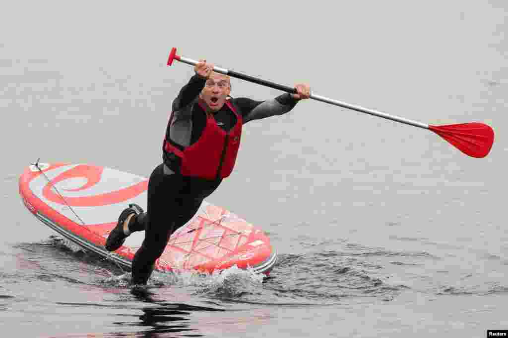 British leader of the Liberal Democrats party Ed Davey falls from a paddle board, at Lake Windermere in Windermere.
