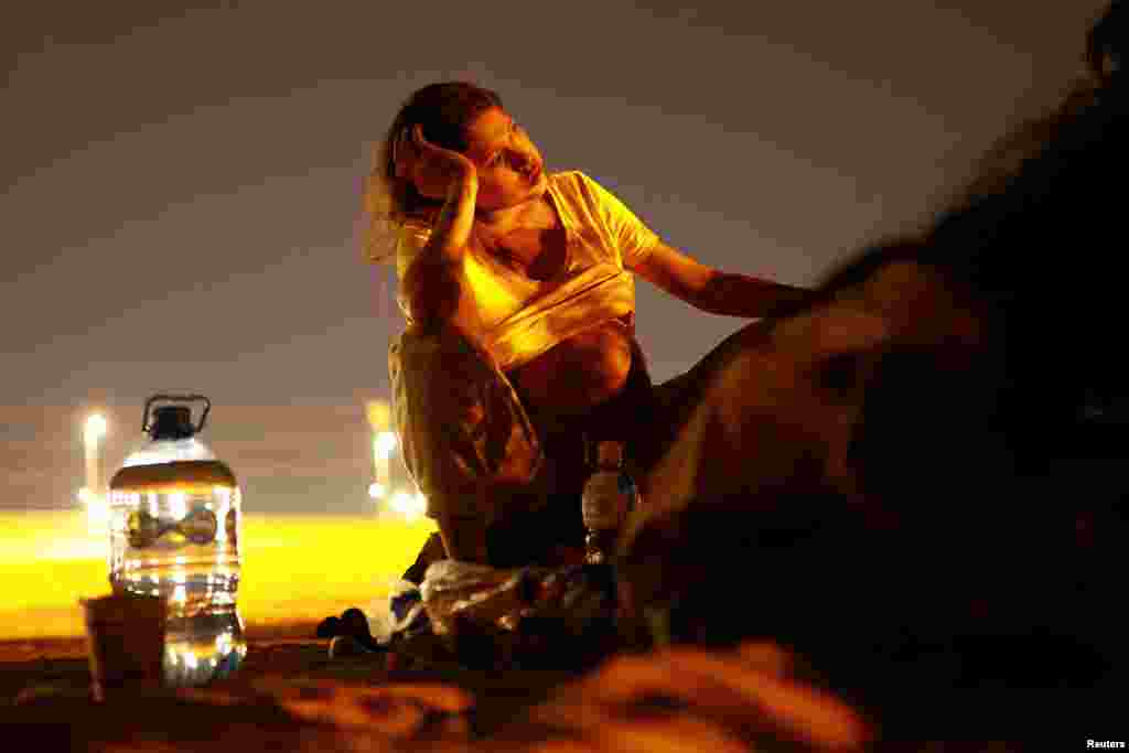 Antonela, a Venezuelan migrant who is eight months pregnant and trying to reach the United States, rests near the Rio Bravo river on the border between Mexico and the United States as seen from Ciudad Juarez, Mexico, June 4, 2024.