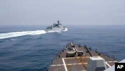 在美国海军提供的这张照片中，美国海军 "钟云号 "号观测到一艘中国海军舰艇在台湾海峡进行它所说的 "不安全 "操作。（2023年6月3日）