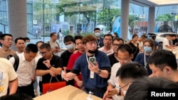 深圳一家华为商店的店员在向人们展示Mate 60系列手机。（2023年8月30日）