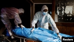 FILE - Workers receive the exhumed bodies of followers of a Christian cult who believed they would go to heaven, if they starved themselves to death in Shakahola, at the Malindi sub district hospital mortuary in Malindi, Kenya, Apr. 27, 2023. 