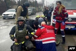 Foto yang dirilis oleh Layanan Darurat Ukraina menunjukkan tim penyelamat dan staf medis memberikan bantuan kepada petugas penyelamat yang terluka menyusul serangan rudal di Odesa, Ukraina, Jumat 15 Maret 2024.