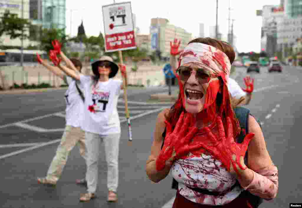 Mothers of combat soldiers who are serving in the Gaza Strip, covered with red paint, block a road demanding the end to the ongoing conflict in Gaza between Israel and the Palestinian Islamist group Hamas, in Tel Aviv, Israel.