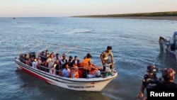 Some Rohingya Muslim refugees and Bangladeshi officials on a boat return after visiting Myanmar's Rakhine State as part of an effort to encourage their voluntary repatriation, in Teknaf, Cox's Bazar, Bangladesh, May 5, 2023.