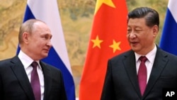 FILE - Chinese President Xi Jinping, right, and Russian President Vladimir Putin pose for a photo during their meeting in Beijing, China, on Feb. 4, 2022.