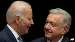 ARCHIVO: Los presidentes de Estados Unidos, Joe Biden, y México, Andrés Manuel López Obrador, sonríen durante una reunión el 9 de enero en la Ciudad de México.