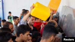 Sejumlah warga Palestina berkumpul di Khan Younis, wilayah selatan Gaza, untuk mendapatkan air di tengah kekurangan pasokan air yang melanda akibat perang Israel-Hamas, pada 15 Oktober 2023. (Foto: Reuters/Mohammed Salem)