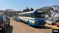 An overloaded bus carrying supporters of Zimbabwe President Emmerson Mnangagwa arrives at arriving at the National Sports Stadium in Harare, Sept. 4, 2023, for his inauguration. (Columbus Mavhunga/VOA)