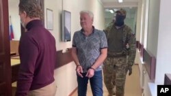 FILE - In this handout photo taken from video released by Lefortovo District Court, Robert Shonov walks to the courtroom at the Lefortovo District Court in Moscow, May 18, 2023.