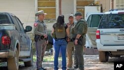 ARCHIVO - Los agentes del orden trabajan en el vecindario donde un hombre armado, aún prófugo, mató a cinco personas el viernes por la noche, en Cleveland, Texas, el 30 de abril de 2023.
